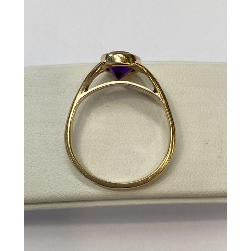 48 - AN ELEGANT 14CT YELLOW GOLD BEZEL AMETHYST RING, oval cut amethyst bezel set with split shank design... 