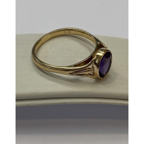 48 - AN ELEGANT 14CT YELLOW GOLD BEZEL AMETHYST RING, oval cut amethyst bezel set with split shank design... 