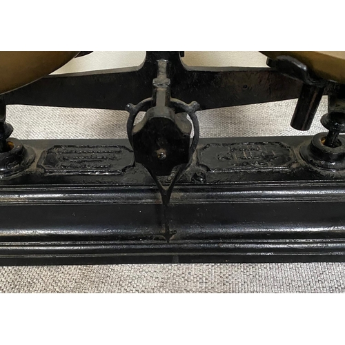 149 - AN ANTIQUE HEAVY CAST IRON TABLE TOP / KITCHEN SCALES, with a pair of brass pans, the base with make... 