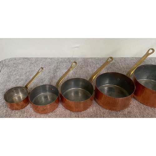 151 - A VERY GOOD SET OF SEVEN COPPER SAUCEPANS, each with heavy brass handles.