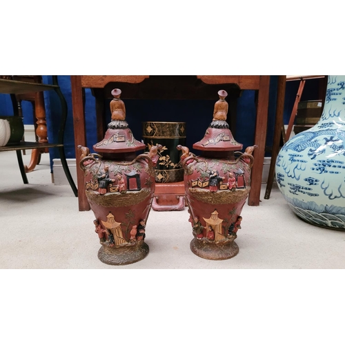 216 - A PAIR OF UNUSUAL HIGH RELIEF JAPANESE / CHINESE STYLE LIDDED URNS, each of baluster shape, with oct... 