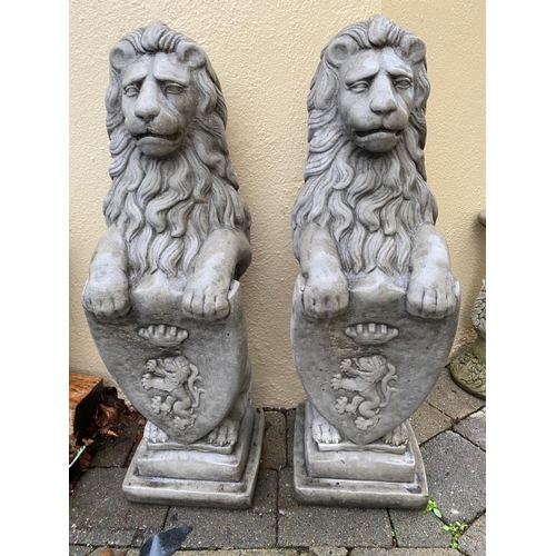 234 - A PAIR OF GARDEN ORNAMENTS IN THE FORM OF TWO LIONS SEATED HOLDING SHIELDS TO THE FRONT, each 86cm t... 