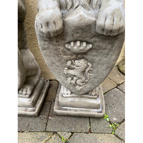 234 - A PAIR OF GARDEN ORNAMENTS IN THE FORM OF TWO LIONS SEATED HOLDING SHIELDS TO THE FRONT, each 86cm t... 