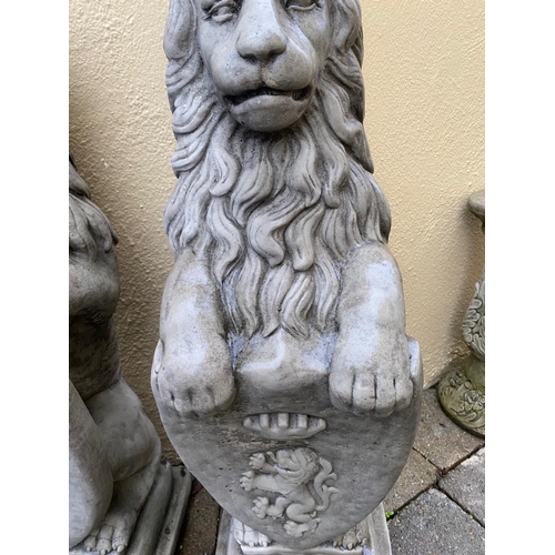 234 - A PAIR OF GARDEN ORNAMENTS IN THE FORM OF TWO LIONS SEATED HOLDING SHIELDS TO THE FRONT, each 86cm t... 