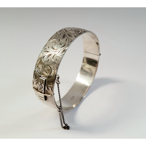 24 - A BEAUTIFULLY DECORATED MID CENTURY SILVER BANGLE/BRACELET, divided into two sections by a hinge, on... 