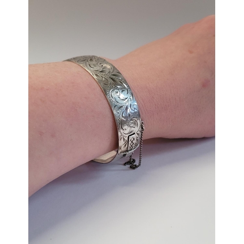 24 - A BEAUTIFULLY DECORATED MID CENTURY SILVER BANGLE/BRACELET, divided into two sections by a hinge, on... 