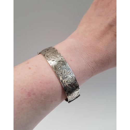 24 - A BEAUTIFULLY DECORATED MID CENTURY SILVER BANGLE/BRACELET, divided into two sections by a hinge, on... 