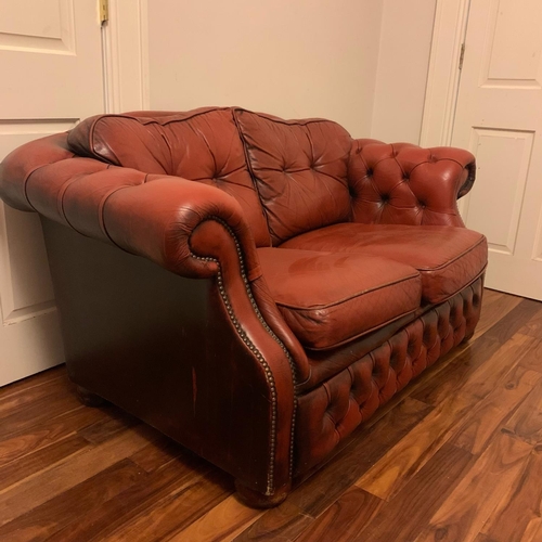 243 - A GOOD QUALITY CHESTERFIELD TWO SEATER SETTEE IN OX-BLOOD RED LEATHER, with roll over back & arm res... 