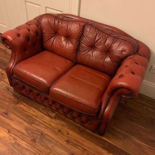 243 - A GOOD QUALITY CHESTERFIELD TWO SEATER SETTEE IN OX-BLOOD RED LEATHER, with roll over back & arm res... 