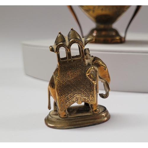 42 - A COLLECTION OF INIDAN BRASS ONAMENTS, including an urn shaped ornament engraved with figural design... 