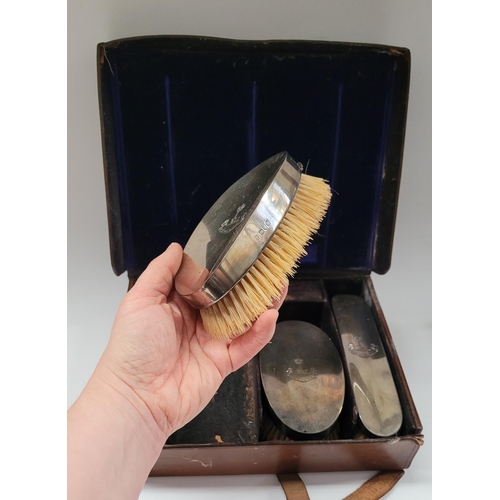 43 - A LATE TURN OF THE CENTURY CASED SILVER TOPPED CLOTHES BRUSH SET, original lined leather travel case... 