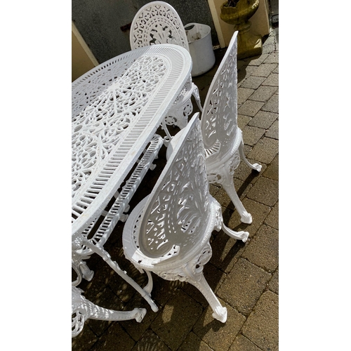 8 - A DECORATIVE CAST IRON GARDEN TABLE WITH CHAIRS, oval table with undertier joined by scrolling feet,... 