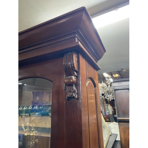 120 - A VICTORIAN MAHOGANY GLAZED BOOKCASE, with cornice above arched glass panelled doors, with carving t... 