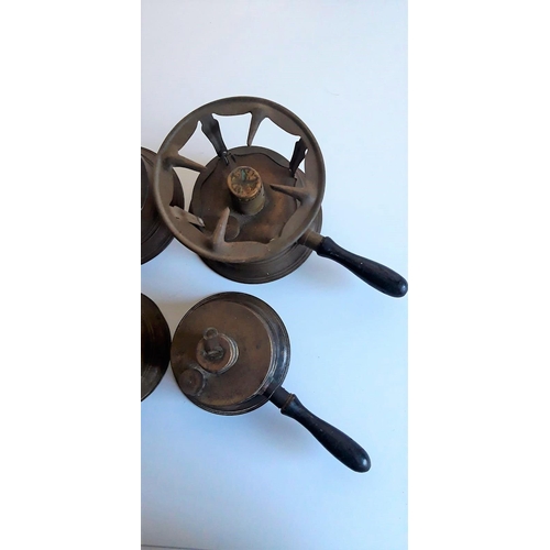 130 - FOUR EARLY 20TH CENTURY BRASS SPIRIT STOVES each with a turned wooden handle. Varying sizes: 15-13cm... 