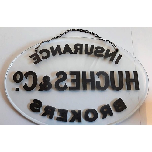 132 - AN OVAL GLASS ADVERTISING SIGN, with gilded lettering & bevelled edges, complete with an original ha... 