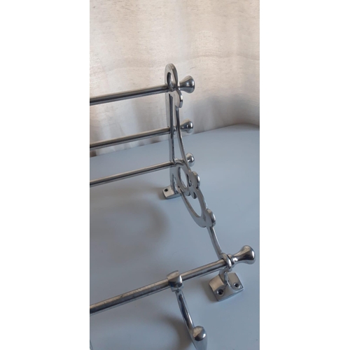 133 - A PULLMAN LUGGAGE RACK, with scrolling open work to the side supports and a series of hooks to the b... 