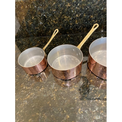 141 - A VERY GOOD SET OF FOUR COPPER SAUCEPANS, with brass handles.