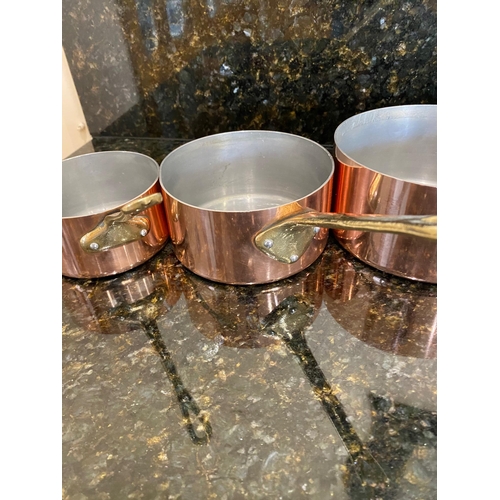 141 - A VERY GOOD SET OF FOUR COPPER SAUCEPANS, with brass handles.