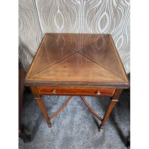 142 - AN EDWARDIAN MAHOGANY INLAID FOLD OUT ENVELOPE CARD TABLE / GAMES TABLE, the top which twists and fo... 