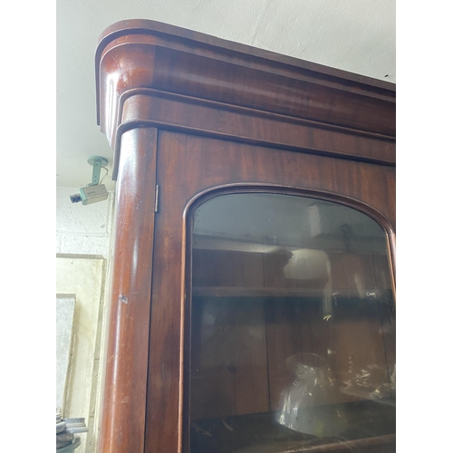 150 - A VICTORIAN MAHOGANY SECRETAIRE, with cornice above arched glass panelled doors, opening to shelved ... 