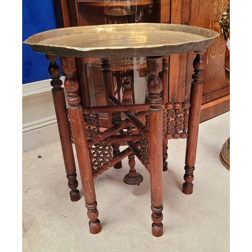 178 - AN INDIAN BRASS TRAY TABLE with folding turned wooden base, nice decorative antique piece, the tray ... 