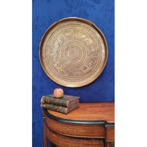 178 - AN INDIAN BRASS TRAY TABLE with folding turned wooden base, nice decorative antique piece, the tray ... 