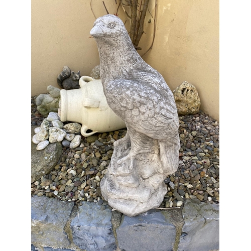 204 - A PAIR OF GARDEN STONE ORNAMENTS IN THE FORM OF TWO EAGLES, each standing upon a rock style base. 60... 