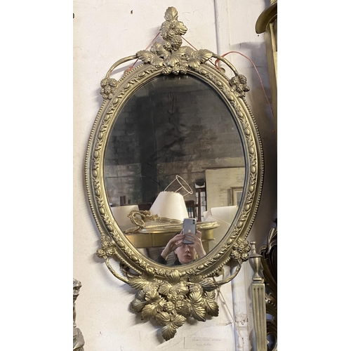 51 - A DEOCRATIVE 19TH CENTURY GILT OVAL WALL MIRROR, the frame highly decorated with attractive patterne... 