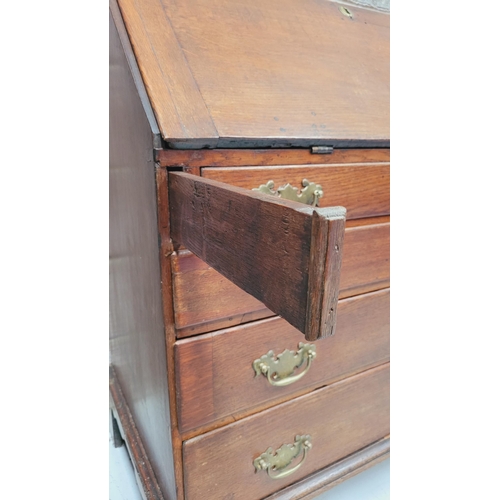 59 - AN OAK DROP FRONT SECRETAIRE DESK, four graduated drawers each with brass swing handles, raised on b... 