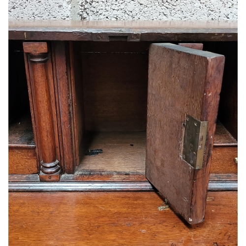 59 - AN OAK DROP FRONT SECRETAIRE DESK, four graduated drawers each with brass swing handles, raised on b... 