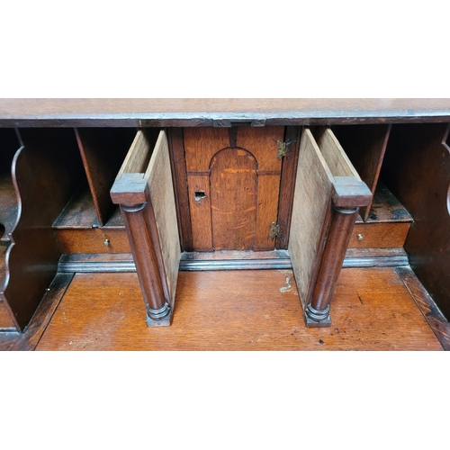 59 - AN OAK DROP FRONT SECRETAIRE DESK, four graduated drawers each with brass swing handles, raised on b... 