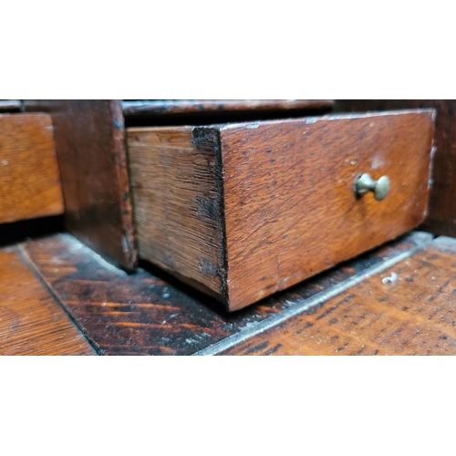 59 - AN OAK DROP FRONT SECRETAIRE DESK, four graduated drawers each with brass swing handles, raised on b... 