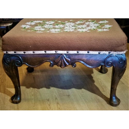 64 - A 19TH CENTURY IRISH MAHOGANY CARVED STOOL, upholstered with a floral tapestry to the stuffed over s... 