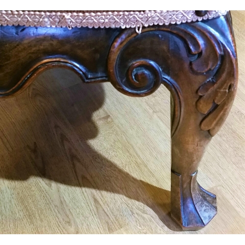 64 - A 19TH CENTURY IRISH MAHOGANY CARVED STOOL, upholstered with a floral tapestry to the stuffed over s... 