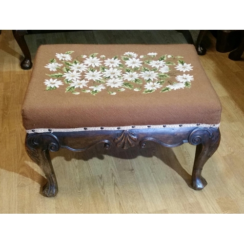 64 - A 19TH CENTURY IRISH MAHOGANY CARVED STOOL, upholstered with a floral tapestry to the stuffed over s... 