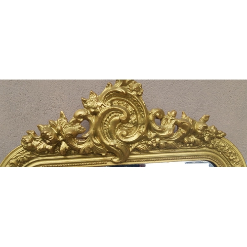 67 - A VERY GOOD QUALITY ANTIQUE GILT WALL MIRROR, topped with a scrolling floral blossom & leaf design, ... 