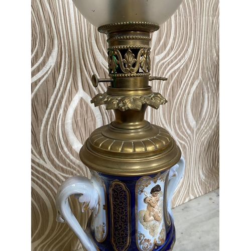 99 - A BEAUTIFUL PAIR OF SEVRES STYLE PORCELAIN & BRASS OIL LAMPS, each with a cobalt blue & gilt coloure... 