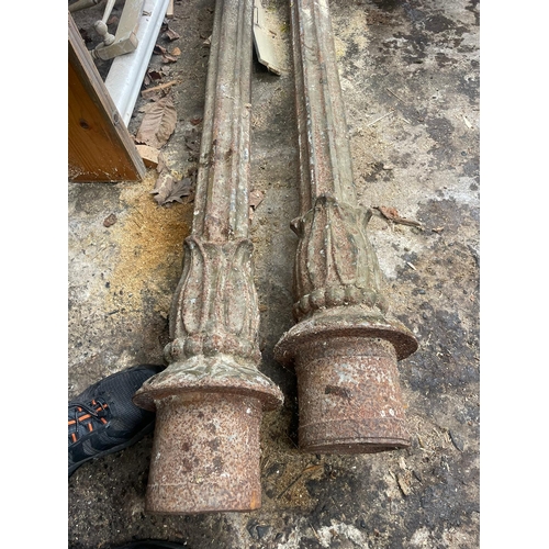 229 - AN ANTIQUE PAIR OF CAST IRON GARDEN LAMPS, each with double head fitting, the graduated column comes... 