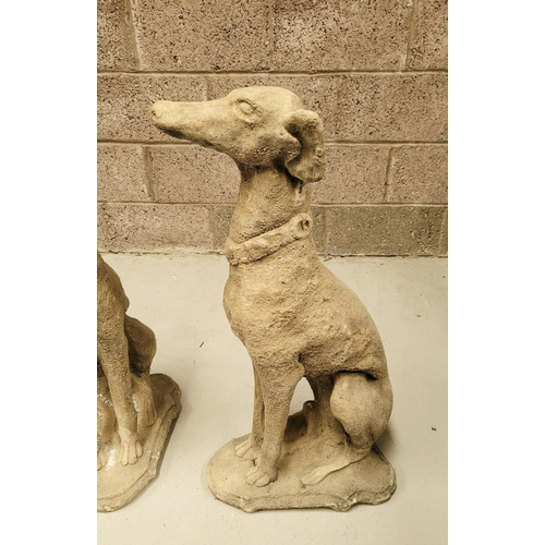 100 - A PAIR OF STONE COMPOSITE GARDEN ORNAMENTS IN THE FORM OF TWO SEATED HOUNDS, each with a collar. Dim... 