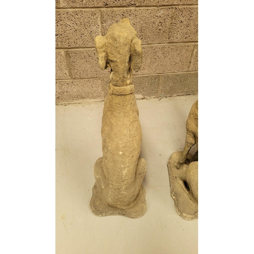 100 - A PAIR OF STONE COMPOSITE GARDEN ORNAMENTS IN THE FORM OF TWO SEATED HOUNDS, each with a collar. Dim... 
