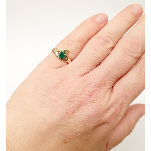 126 - A 10CT YELLOW GOLD EMERALD SET CLADDAGH RING, the emerald piece set to the centre in a heart shape. ... 