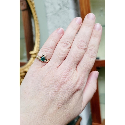 126 - A 10CT YELLOW GOLD EMERALD SET CLADDAGH RING, the emerald piece set to the centre in a heart shape. ... 