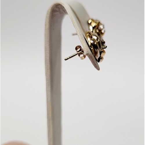 128 - A PAIR OF 9CT DUAL TONED GOLD STUD EARRINGS, with a central solitaire clear gemstone setting, marked... 
