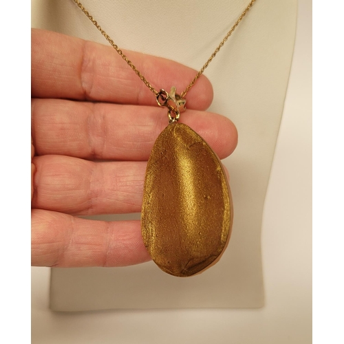 223 - A CASED ALEXIS BITTAR LUCITE & GOLD PENANT NECKLACE, the oval shaped pendant is a bright golden colo... 