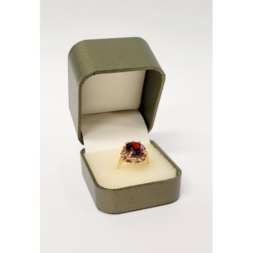 31 - A BEAUTIFUL YELLOW GOLD & GARNET RING, with an open work edge that holds the large oval shaped garne... 
