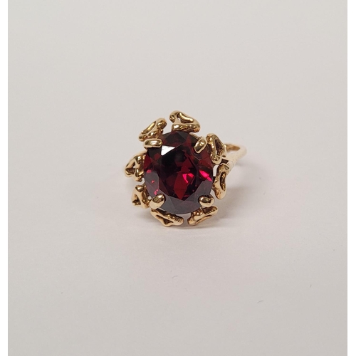 31 - A BEAUTIFUL YELLOW GOLD & GARNET RING, with an open work edge that holds the large oval shaped garne... 