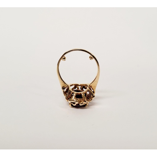 31 - A BEAUTIFUL YELLOW GOLD & GARNET RING, with an open work edge that holds the large oval shaped garne... 