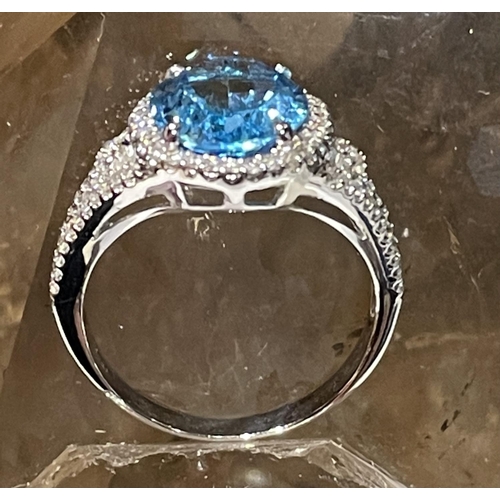 44 - AN 18CT WHITE GOLD BLUE TOPAZ & DIAMOND CLUSTER RING, complete with diamond encrusted shoulders, vib... 