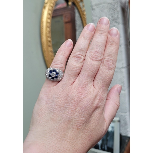 82 - A PRETTY 18CT WHITE GOLD SAPPHIRE & DIAMOND FLORAL CLUSTER / DRESS BOMBE SHAPED RING, the curved set... 