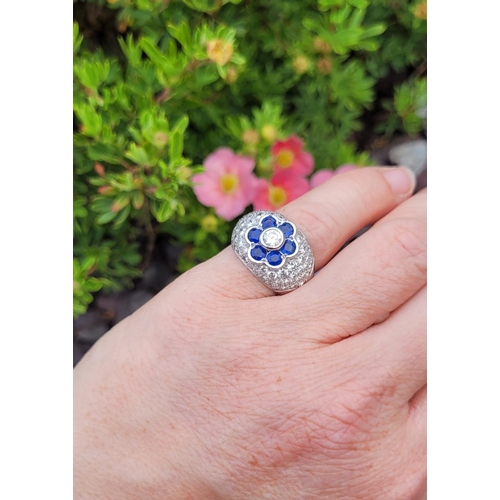 82 - A PRETTY 18CT WHITE GOLD SAPPHIRE & DIAMOND FLORAL CLUSTER / DRESS BOMBE SHAPED RING, the curved set... 